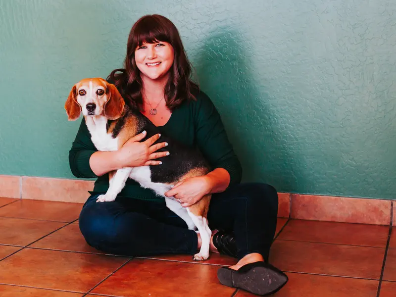 Dr. Bason seated with her beagle Bubby.