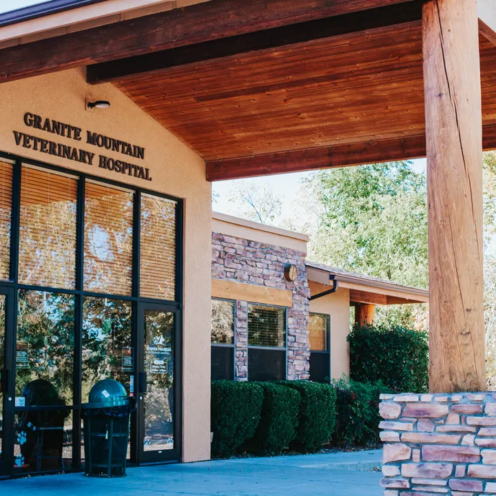 The covered front entrance of Granite Mountain Veterinary Hospital, with the hospital sign mounted on the wood-beam canopy.