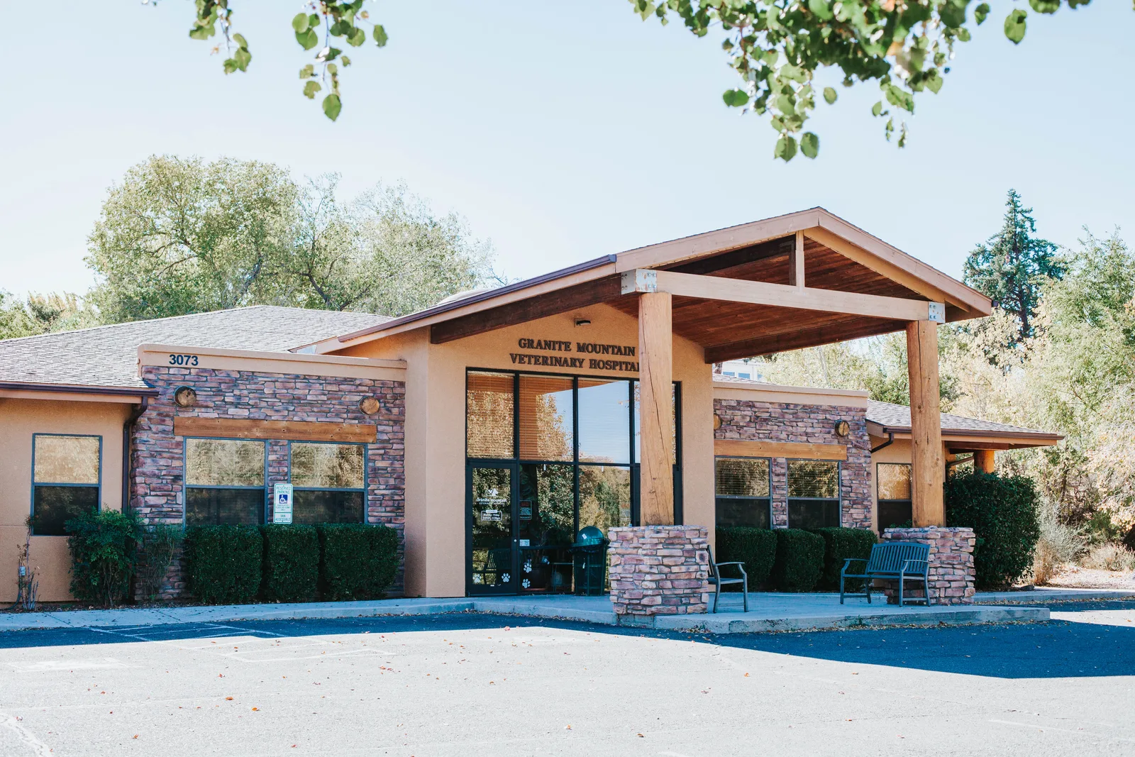 The front entrance of Granite Mountain Veterinary Hospital, with stone columns, a wood-beam canopy, and the hospital sign mounted above the doorway.