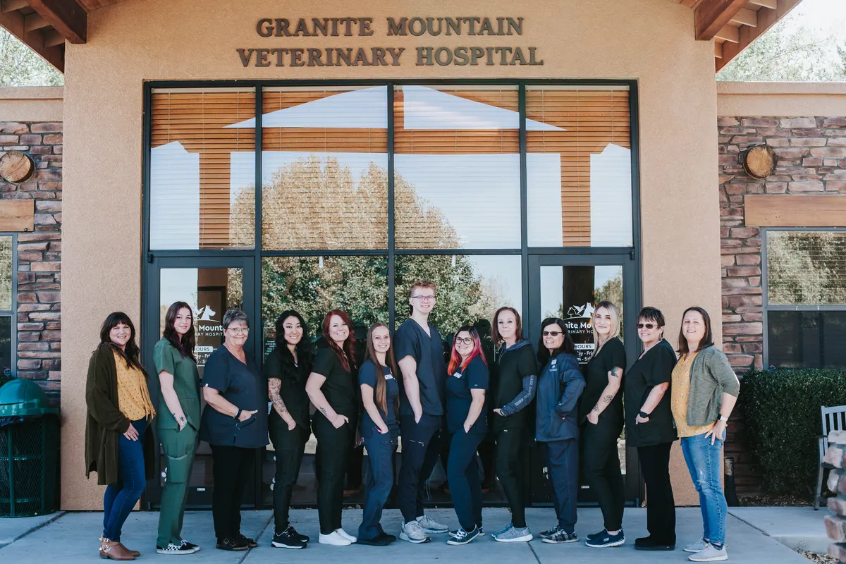 The full Granite Mountain Veterinary Hospital team in front of the practice entrance under the hospital sign.